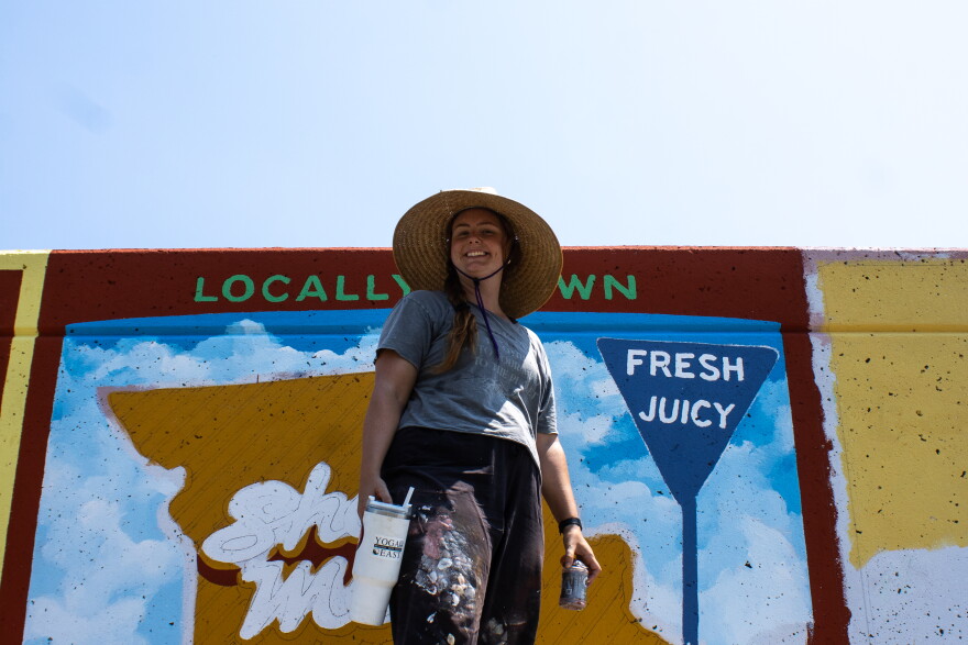 Painter Leah Sparks gleefully smiles atop the scaffolding by the Cape Girardeau, Mo., floodwall on August 11th.