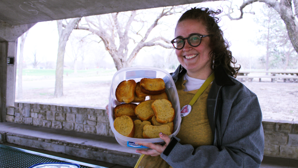 Jenny Pierce, a representative of People's Pride ICT, holds a tray of garlic bread for their event "Gays Eating Garlic Bread in the Park."