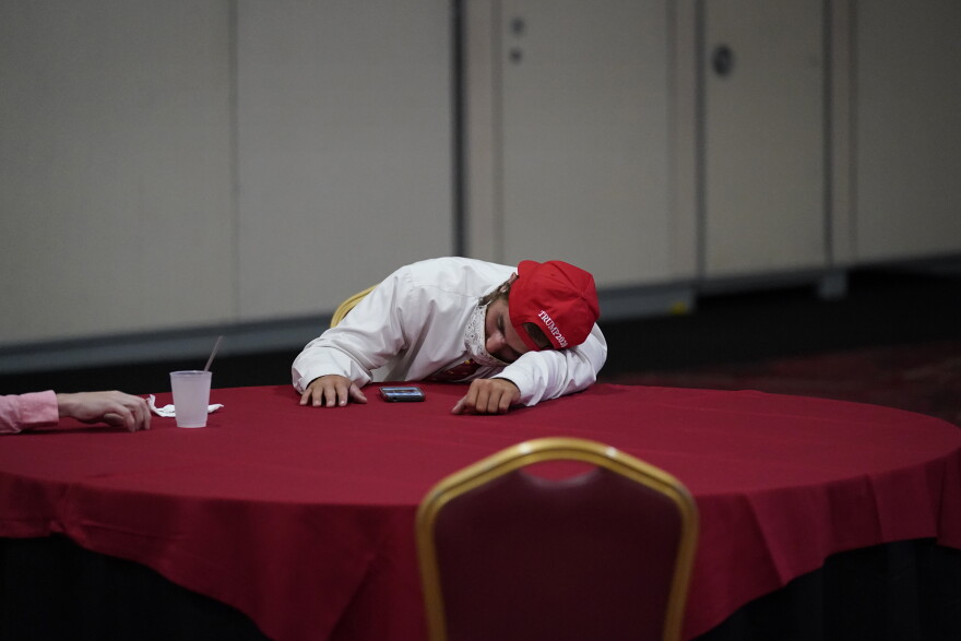 A supporter of President Donald Trump rests on a table while waiting for election results at an election night party, Tuesday, Nov. 3, 2020, in Las Vegas.