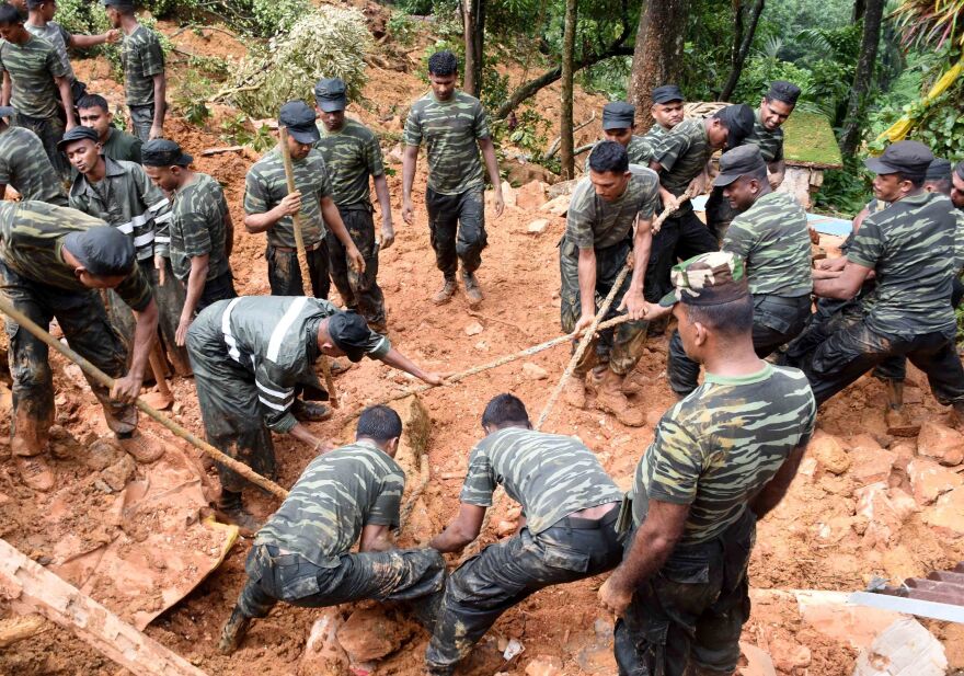 Sri Lankan military personnel work on rescue operations in the village of Bulathkohupitiya on Wednesday. Three days of torrential rain led to landslides in central Sri Lanka.