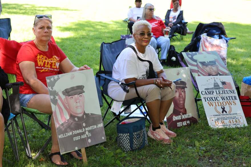 Debbie Fultz Martin (left) and Karen Swindler display photos of their husbands outside the U.S. Capitol on June 4, 2026. Both men died of cancer after serving at Camp Lejeune.
