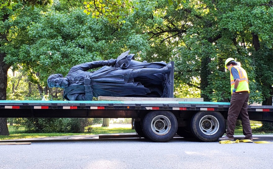 A crew member helps secure the Columbus statue to a trailer, following its removal from Tower Grove Park on June 16, 2020.