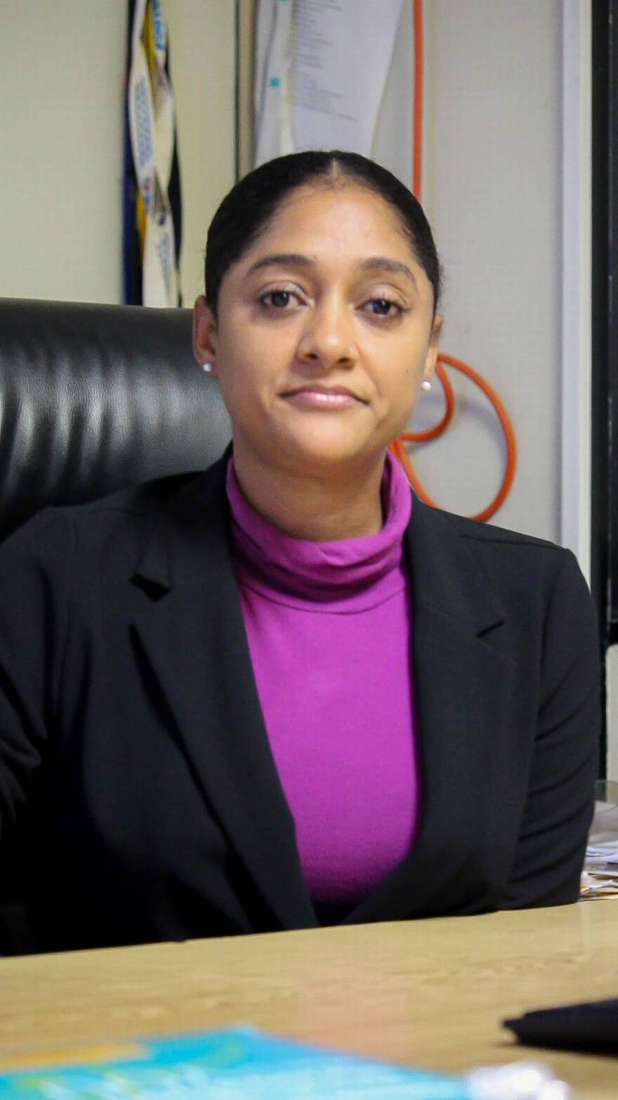A woman in a purple shirt and black blazer.