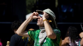 A festival attendee looks at the solar eclipse during ACL Fest on Oct. 14. 