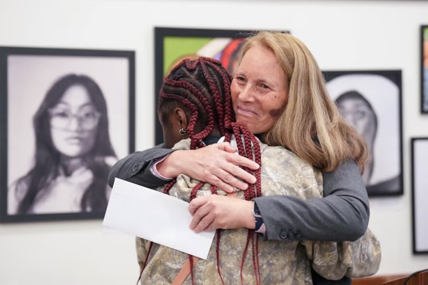 Judge Halee Weinstein, right, embraces student artist Jaylyn Walker after she is announced as this year's winner.