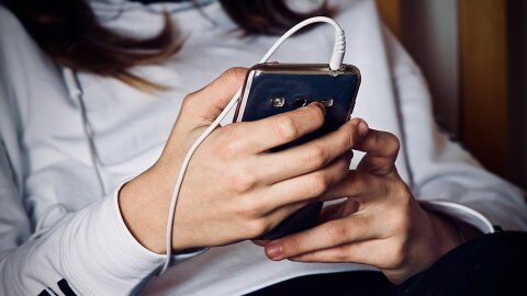A teen holds a cell phone