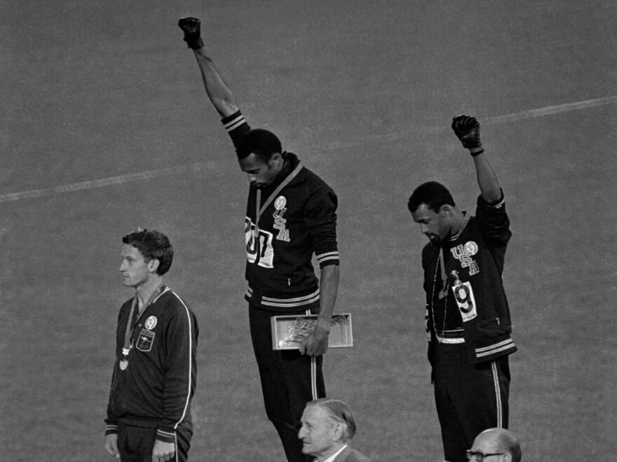 American gold medalist Tommie Smith (center) and bronze medalist John Carlos raise their fists in the air in a black power salute during the playing of the U.S. national anthem at the 1968 Olympics.