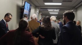 Lobbyists and other stakeholders gather around a screen to watch live committee proceedings on Tuesday, Feb. 4, 2025.