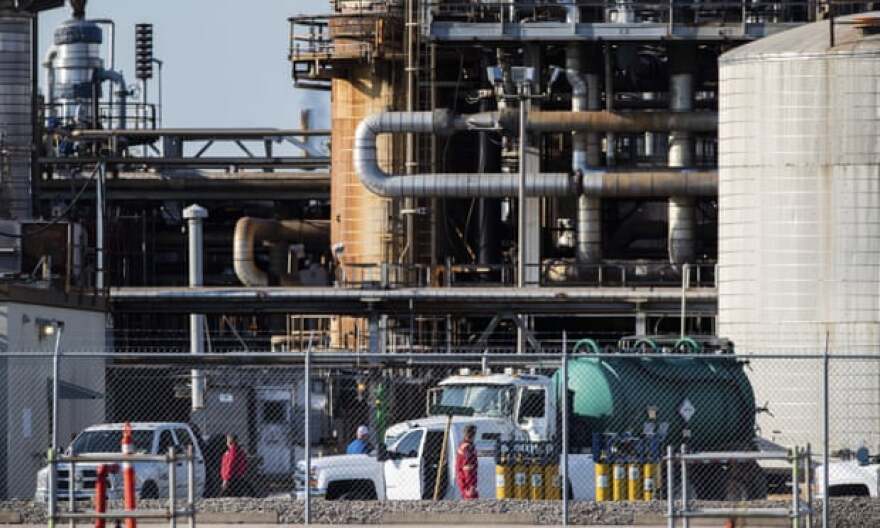 Workers stand in a lot at a facility in La Porte, Texas. A large chemical leak at the Houston-area plant killed two people and left 30 people hospitalized in July 2021.