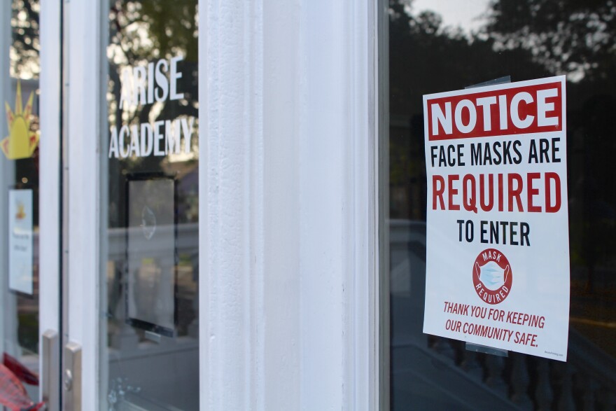 A poster taped to the front door of Arise Academy on St. Claude Ave informs those entering the building that they must wear a mask. 