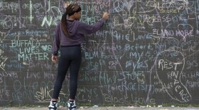 A young girl adds her message to dozens written in chalk on May 23, 2022.