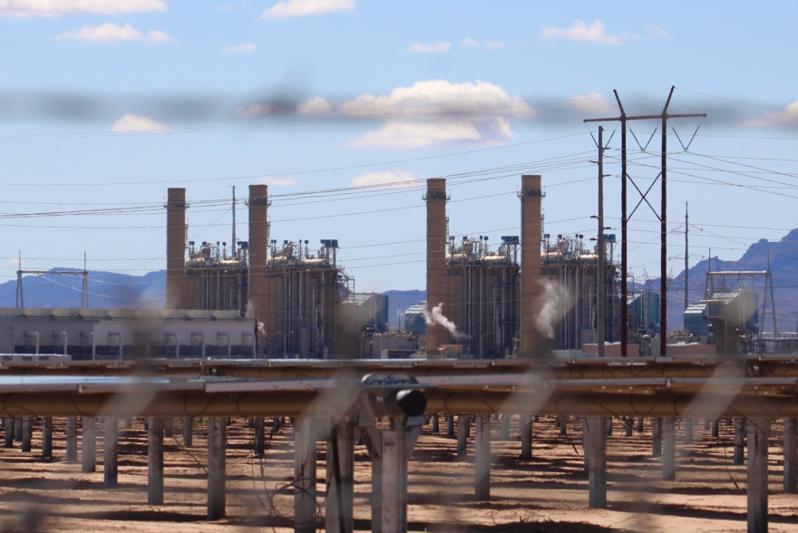 A power plant with several large buildings and electric infrastructure around them, including pipes.