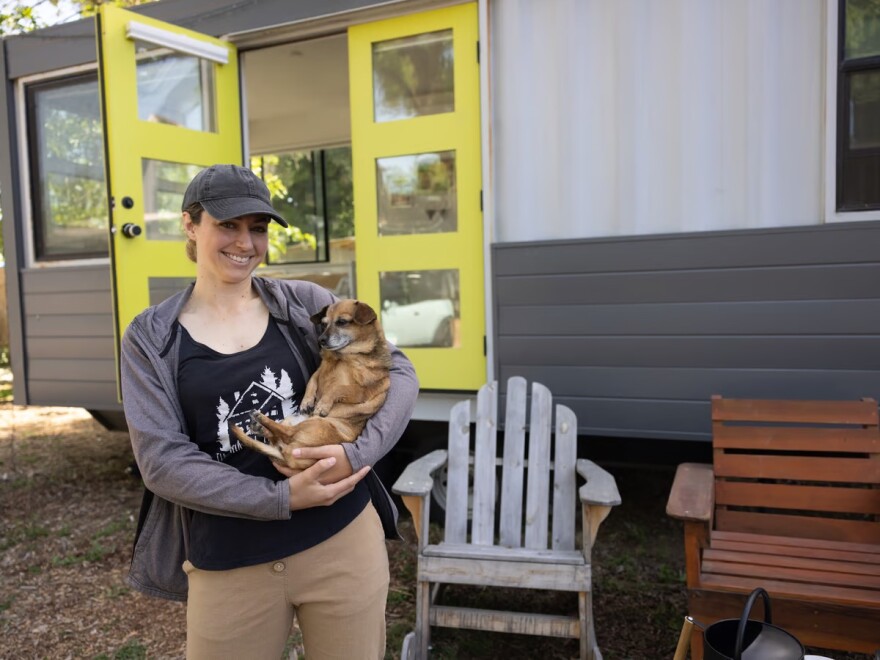 Robyn Davis holds her dog, Ruby, outside their tiny home in West Sacramento Monday, April 24, 2023.