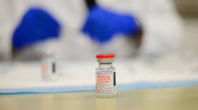 A vial of vaccine on a table