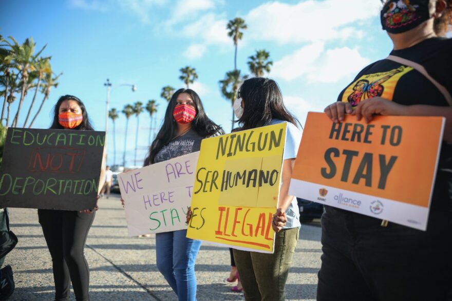 People hold signs during a rally in support of the Supreme Court's ruling in favor of the Deferred Action for Childhood Arrivals (DACA) program, in San Diego, California.