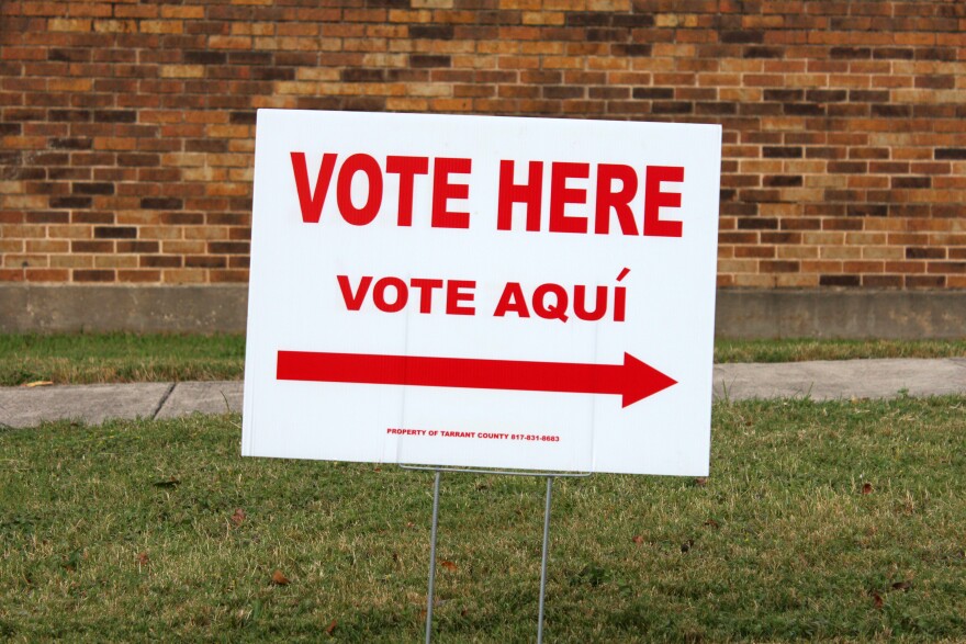 A sign that says "Vote Here" in English and Spanish. 