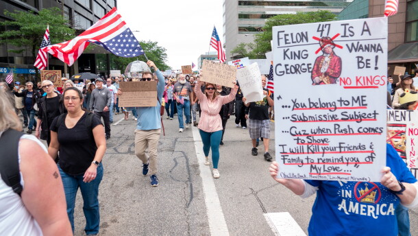 People protesting march with signs.