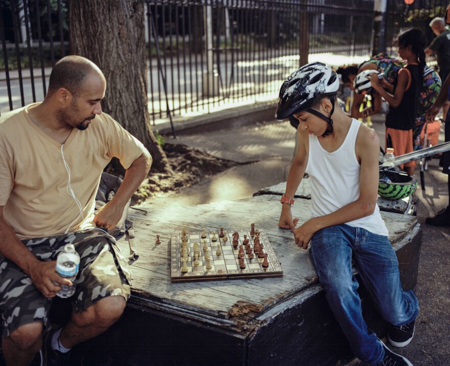 Max playing chess with a young rider, 2016.