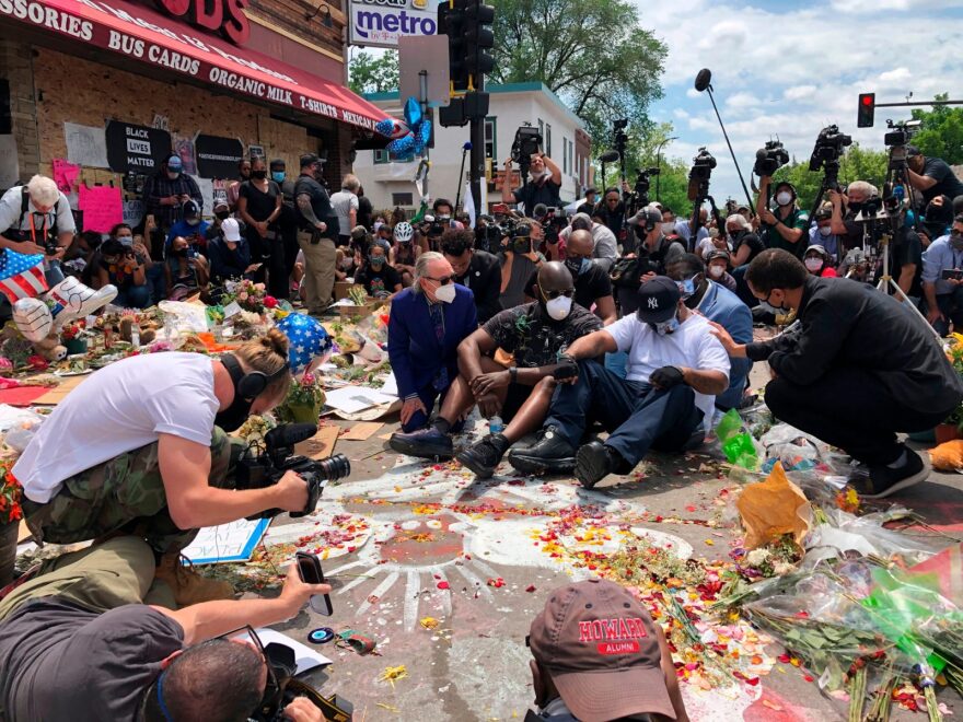 Terrence Floyd (C), sits as people gather at the site where his brother, George Floyd, died in Minneapolis, Minnesota. - 