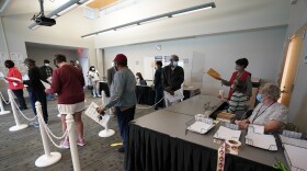 FILE - Early voters line up to cast their ballots inside the South Regional Library polling location in Durham, N.C., Thursday, Oct. 15, 2020. After receiving more than a dozen reports of conduct violations by party-appointed poll watchers during the May primaries in North Carolina, the state elections board tightened regulations for precinct observers on Tuesday, Au. 16, 2022, to prevent partisan interference in the November general election.