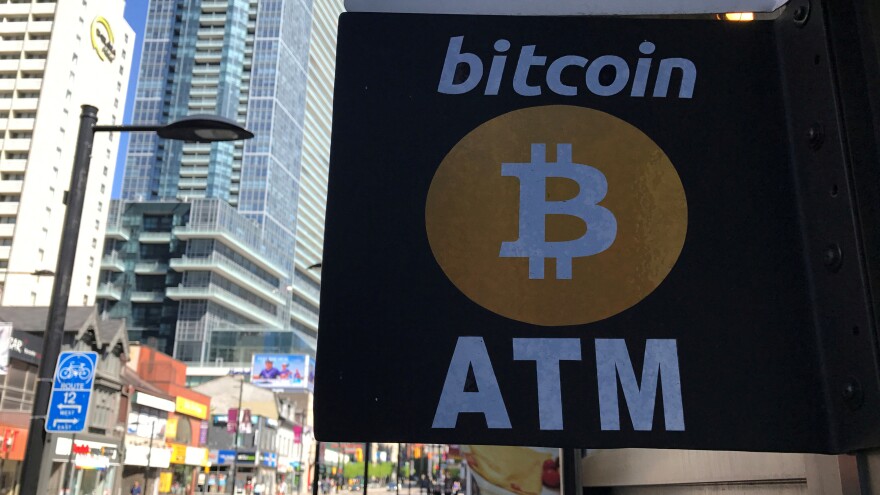 Led by a drop in bitcoin's price, the value of cryptocurrencies fell by more than $40 billion over the weekend and into Monday. Here, a sign advertises a Bitcoin ATM in Toronto, Canada, last summer.