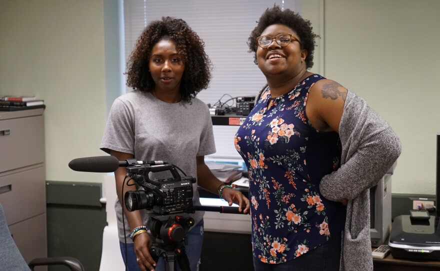 Two Black students smiling and posing for the picture.