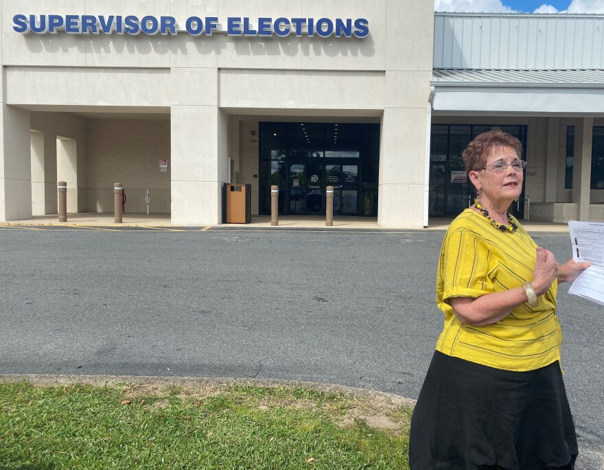 Barbara Devane, secretary for the Florida Alliance for Retired Americans, promotes vote by mail outside the Leon County supervisor of elections office.