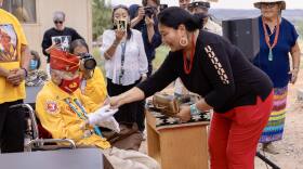 Navajo Nation Veterans Administration Director Bobbie Ann Baldwin presents the 107-year-old Navajo Code Talker John Kinsel, Sr. with a key to his newly renovated home in Lukachukai.