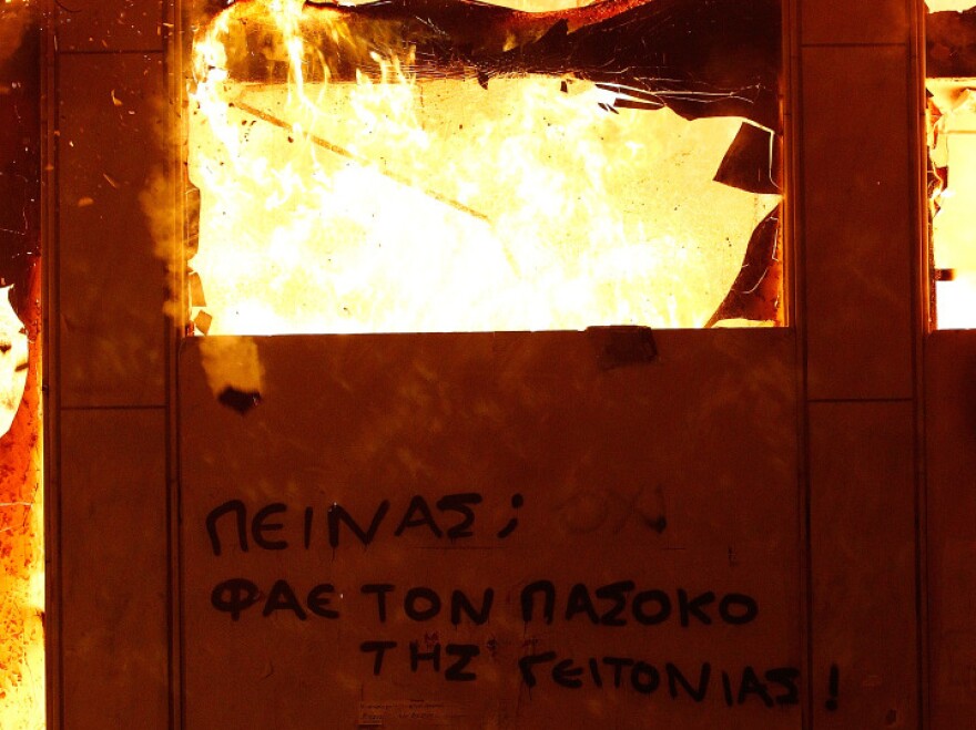 A message on a burning building in the center of Athens saying "Hungry? Eat your local Pasok politician" is seen during the demonstration against the new austerity measures in Syntagma Square on Feb. 12, 2012 in Athens, Greece. Greece's creditors have demanded further austerity measures before approving a new bailout from the European Union.