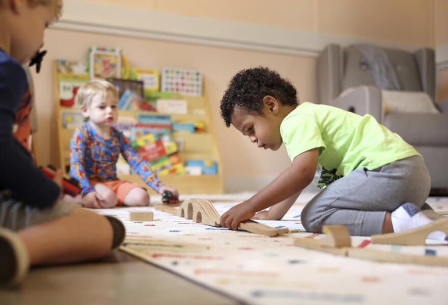 A child plays with a train set at Bumble Art Studio day care center in Astoria, Ore., Friday, Sept. 2, 2022. (Craig Mitchelldyer/AP)