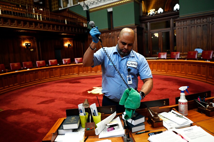 Connecticut's legislature is suspended until at least April 12 to follow the state's social distancing guidelines. Day porter Luis Almenas disinfected all the microphones during a deep clean in the Senate chambers on March 12.