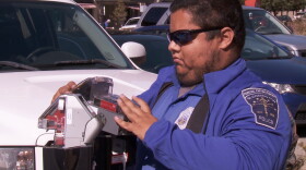 A city employee fixes a parking meter after many were vandalized, Oct. 23, 2019.
