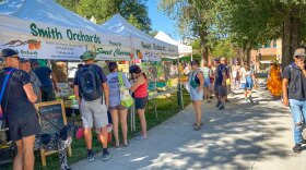 Shoppers in front of Smith Orchards' tent at the Downtown Farmers Market at Pioneer Park in Salt Lake City, July 22, 2023.