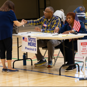 Saginaw Township poll workers Vincent McMillon and May Wathen help a voter prepare to cast her ballot in the Aug. 4, 2026 primary election.