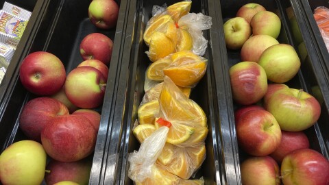 FILE - Apples and orange slices rest in trays for student lunches at the Albert D. Lawton Intermediate School, in Essex Junction, Vt., June 9, 2022.