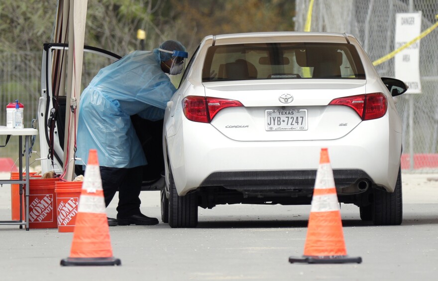 A medical worker tests a person for the coronavirus Tuesday at a drive-through facility primarily for first responders and medical personnel in San Antonio.