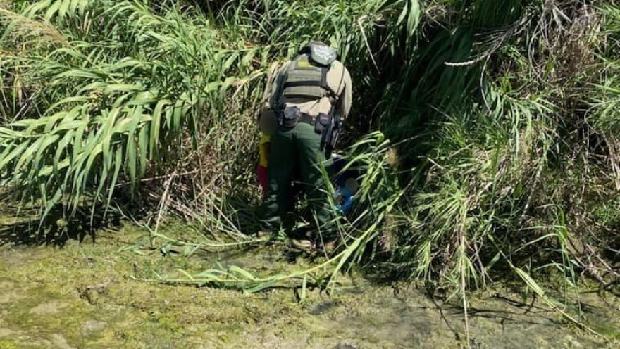 An agent from the U.S. Border Patrol checks on two children who were discovered along the Rio Grande River near Eagle Pass, Texas.