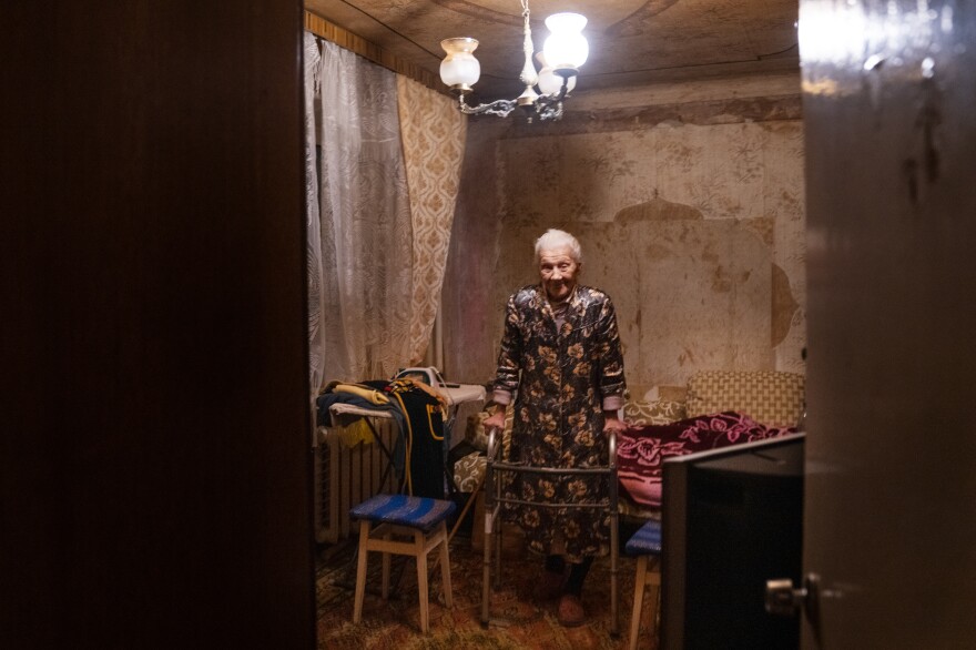 Nadiia Yerkhimovych stands with the help of a walker in her home.