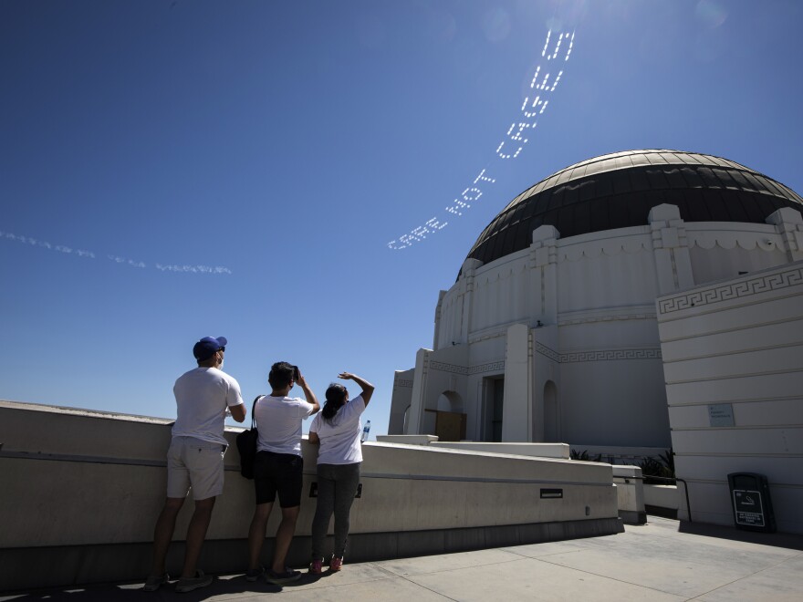 The words "Care, not cages" are viewed from the Griffith Observatory in L.A. The activist Patrisse Cullors had them flown over the city's Men's Central Jail. "What we are challenging the county to do right now is to actually invest into our communities through an alternatives to incarceration fund," says Cullors.