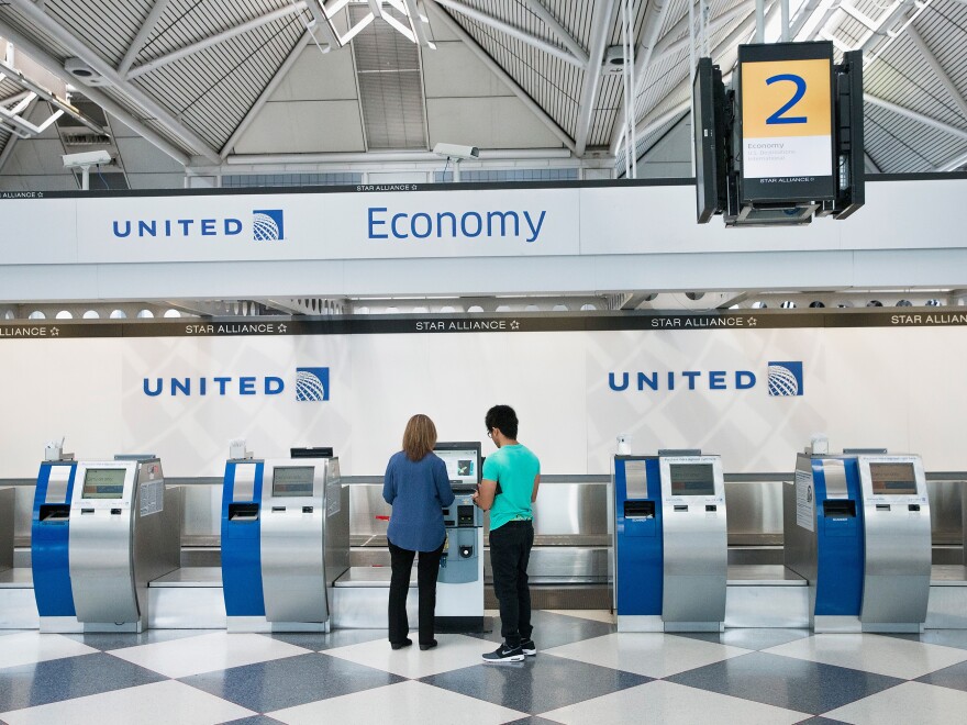 Passengers check in for flights with United Airlines at Chicago O'Hare International Airport. United, American and Delta now offer no-frills "basic economy" fares.