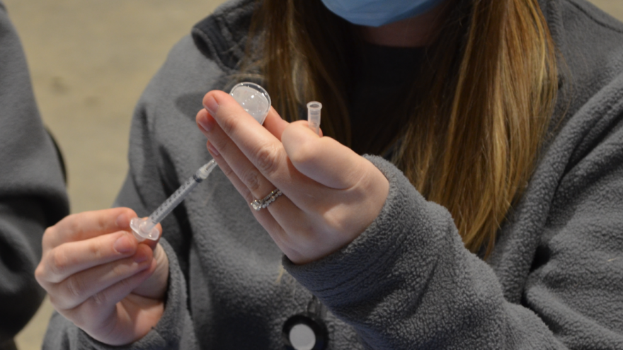 A health care worker fills a vial with the Pfizer vaccine at a COVID-19 shot clinic at the Ohio State Fairgrounds in January 2021.