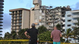 Local residents view the wreckage of the Champlain Towers South condo building in Surfside hours after it collapsed last Thursday.