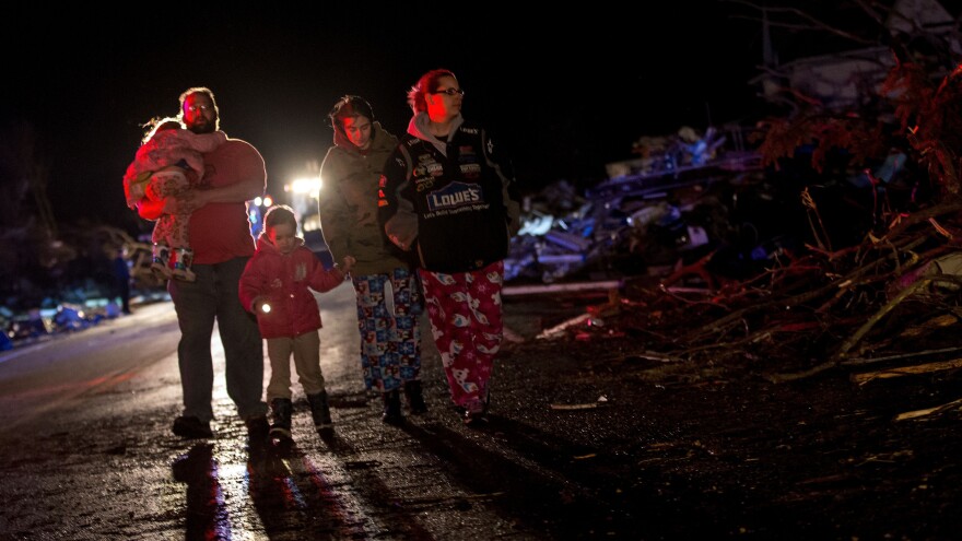 Stefanie and Matthew Hurley and their family look at wreckage after a tornado came through the town of Fairdale, Ill., earlier in the day Thursday.