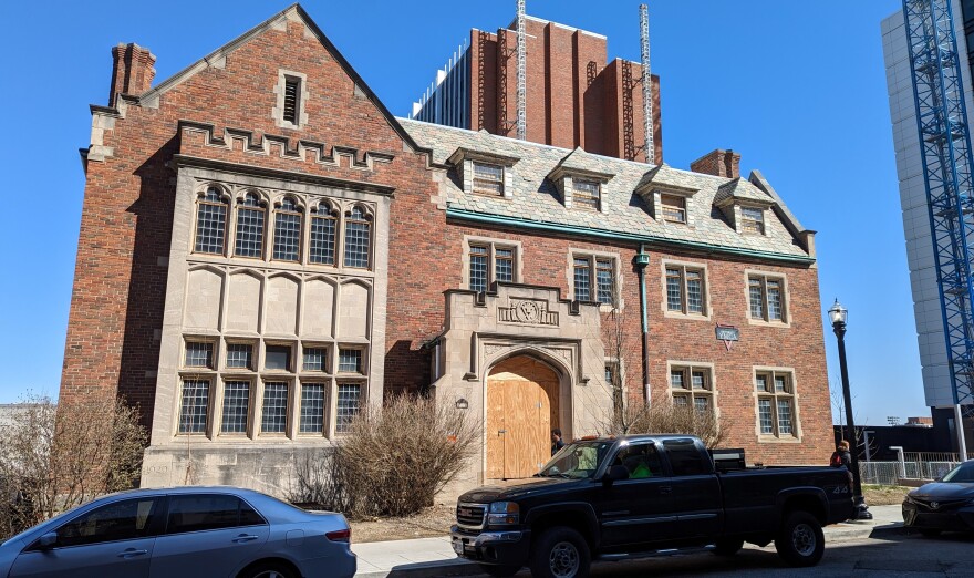 The former YMCA building, a gothic style structure sits along Calhoun Street. The front door has a sheet of plywood over it.