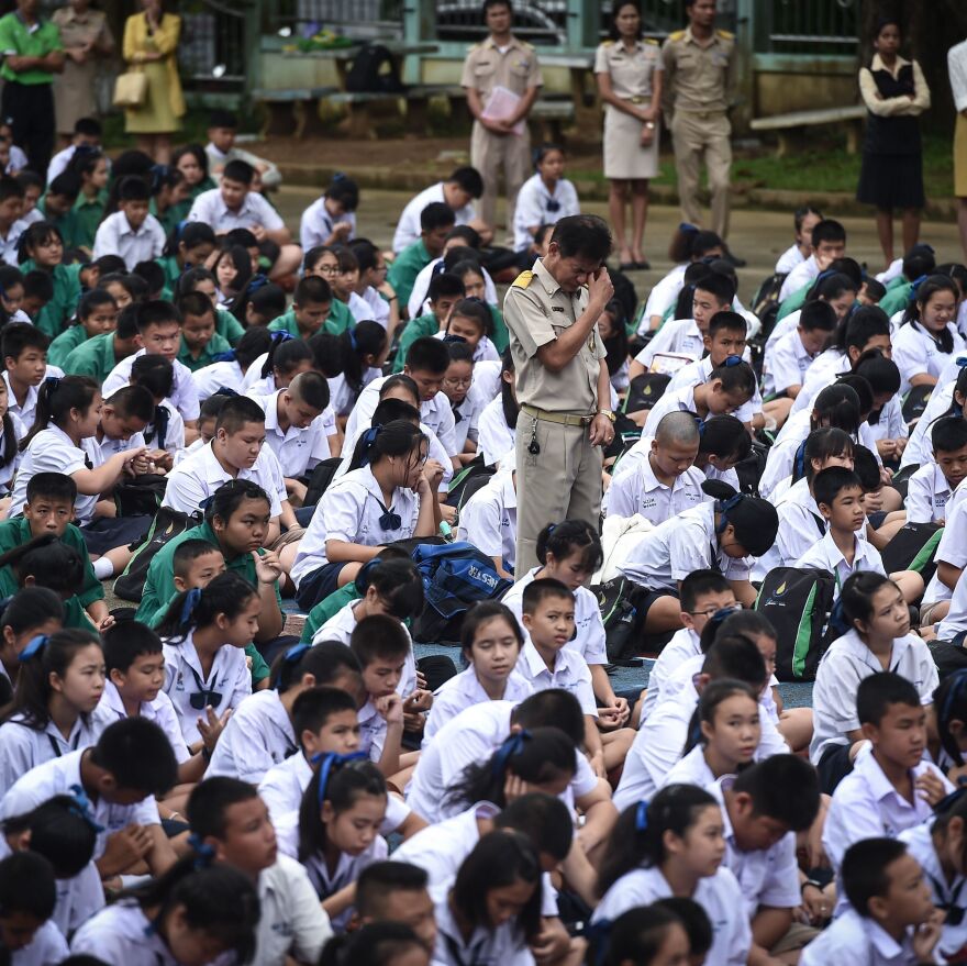 Thai schoolchildren and their teachers pray on Monday for classmates who went missing June 23 inside the Tham Luang Nang Non cave in Chiang Rai.