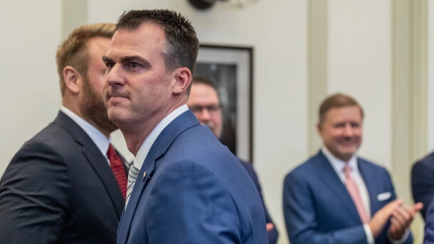 Kevin Stitt (center) makes his way past an applauding Attorney General Gentner Drummond (right) at the 2023 State of the State Address.