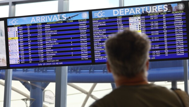 A traveler checks the arrivals and departures board at Frederick Douglass Greater Rochester International Airport on Friday, July 19, 2024.