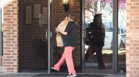 A woman is seen bringing food into the Grace Skilled Nursing and Therapy in Norman on March 26.
