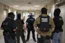 Federal agents stand outside an immigration court at the Jacob K. Javits federal building, Thursday, July 17, 2025, in New York.