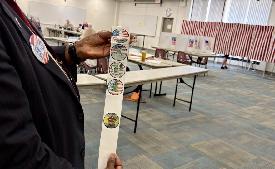 An election official at Manchester's Ward 3, the Carol Rines Center, shows off the new "I Voted" stickers during the state primary election Sept. 8, 2026.